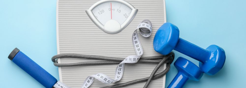 Scale and weight loss tools on blue background ready for a weight loss journey