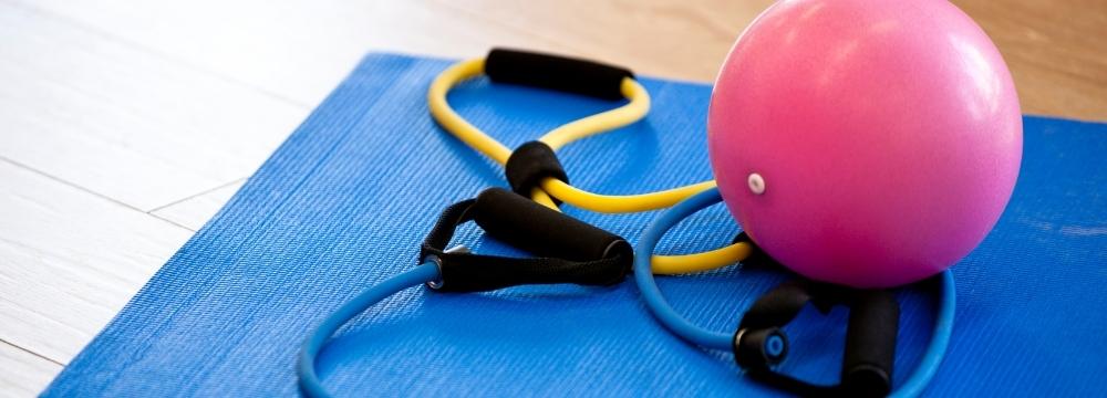 yoga ball and exercise bands on a blue yoga mat