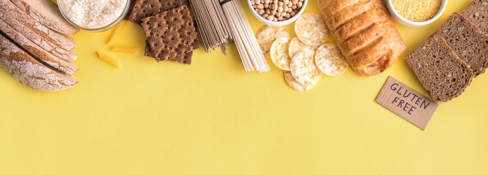 various foods containing gluten, bread, crackers, pasta, next to gluten free sign