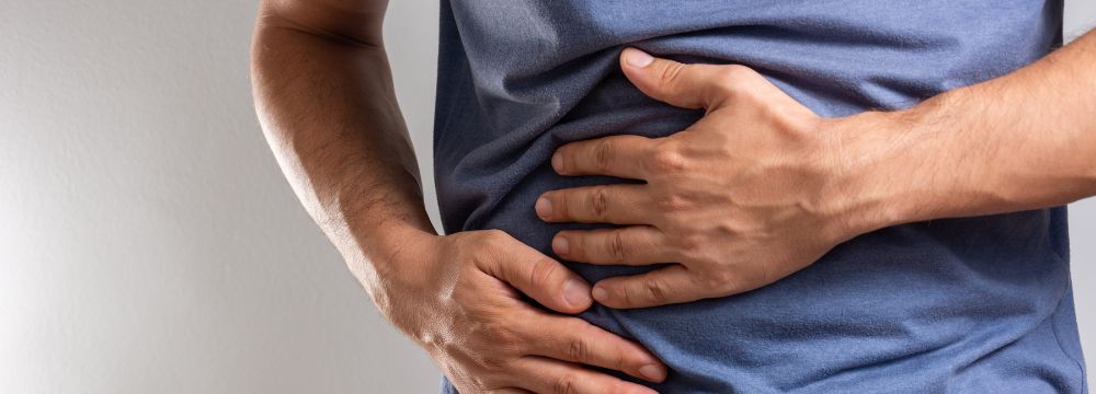 Man grabbing side and abdomen from hernia pain
