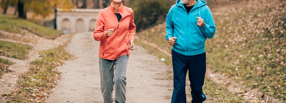 man and woman running together on road