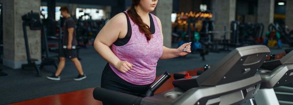 Woman working out at gym on treadmill