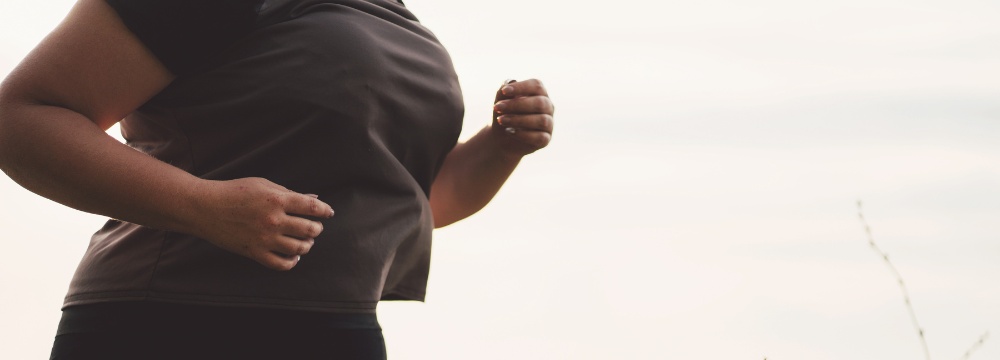 Woman jogging outdoors using arms for momentum